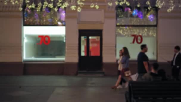 Rua movimentada. Pedestres ambulantes. Banners anunciando a venda. Luzes de Natal — Vídeo de Stock