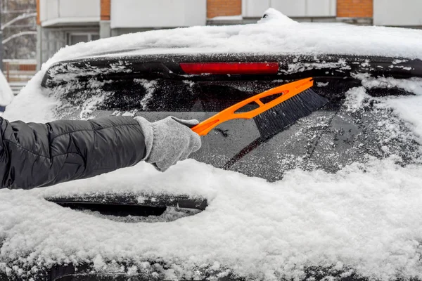 Homem usando escova para remover a neve do carro — Fotografia de Stock