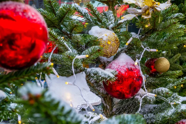 Χριστουγεννιάτικο δέντρο καλυμμένο με χιόνι. Παιχνίδια χριστουγεννιάτικων δέντρων, μπάλες και γιρλάντες — Φωτογραφία Αρχείου