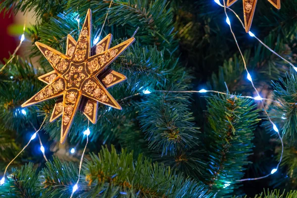 Noel yıldızı ve parlak çelenkler dalları süslüyor — Stok fotoğraf