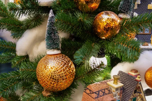 Gold- und silberfarbenes Weihnachtsspielzeug, ein leuchtender Kranz hängt — Stockfoto