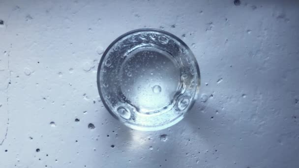 Transparant glas gevuld met sprankelend mineraalwater. Bubbels stijgen naar het oppervlak — Stockvideo