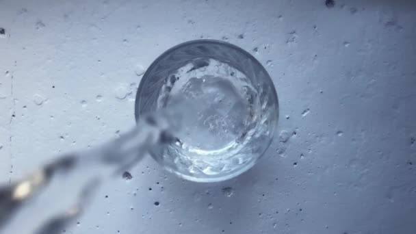 Töltök egy tiszta poharat hideg vízzel, fehér beton alapon. Fogalom — Stock videók