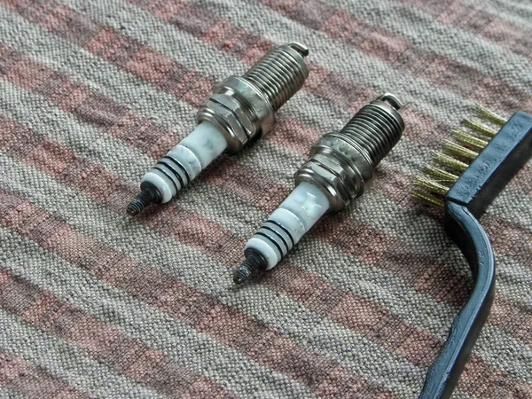 Spark plugs automobile and brush lie on the table — Stock Photo, Image