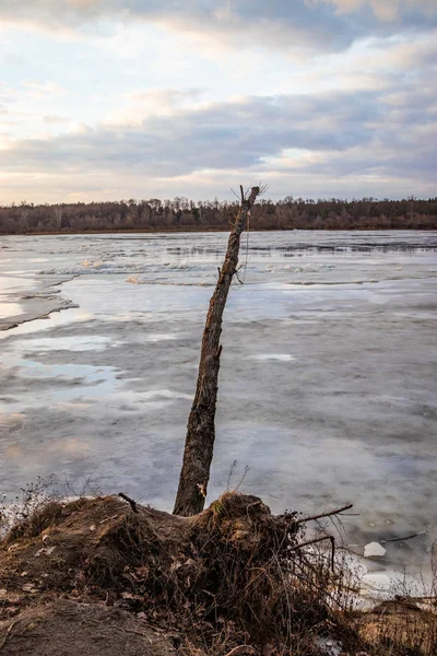 The descent of ice in the spring on the river in March is a natural phenomenon against the sky and clouds in the evening. — Stock Photo, Image