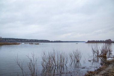 Derin sakin bir bulutlu gökyüzü karşı bahar akşam nehirde