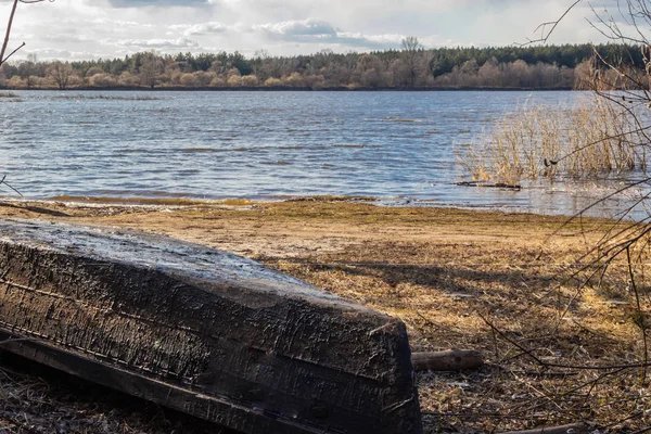 Old perahu nelayan kayu di tepi sungai menunggu musim navigasi . — Stok Foto