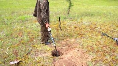 Hazine avcısı bir metal dedektörü ve hazine ve takı arayışı içinde bir kürek ile alanında, bir hobi olarak arkeoloji, tarihi miras aramak