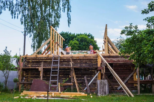 Instalación de un nuevo techo de madera en una vivienda por un equipo de carpinteros y techadores — Foto de Stock