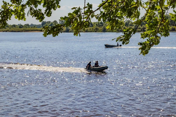 Sportfiskare gå motorbåt på en flod som söker fisk på en solig sommardag — Stockfoto