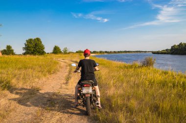 Yeni bir rota arayışı içinde nehre paralel bir motosiklet sürme