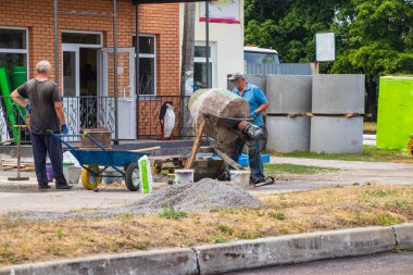 İnşaatçılar Beton mikser ile somut bir çözüm yoğurma.