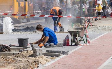İnşaatçılar endüstriyel ekipman ile kaldırım tamir