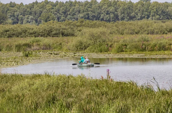 Fiskare i en båt simma i en damm — Stockfoto