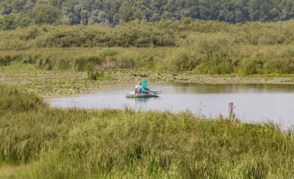 Fiskare i en båt simma i en damm — Stockfoto