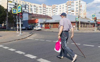 Koltuk değneği özürlü kişi bir çapraz yürüyen yol geçiyor