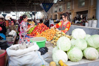Semerkand, Özbekistan, Ekim, 2016: Ana Pazar (bazaar) fiyatlarla pazarlık kadınların, onlardan biri sebze satın alıyor. Lahana ön plan üzerinde yığını