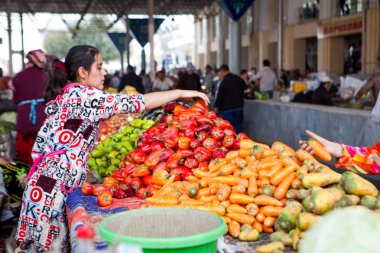 Semerkand, Özbekistan, Ekim, 2016: Ana Pazar (bazaar) fiyatlarla pazarlık kadınların, onlardan biri sebze satın alıyor. Lahana ön plan üzerinde yığını
