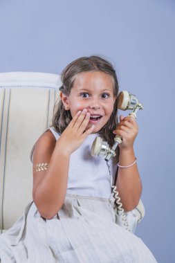 sürpriz yüz ile eski telefon ile konuşurken elbiseli kız