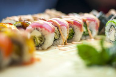 Suşi çubukla yemek. Suşi restoranında Japon gıda rulo. California suşi roll somon, sebze, uçan balık roe ve havyar closeup ile ayarlayın. Japonya restoran menü