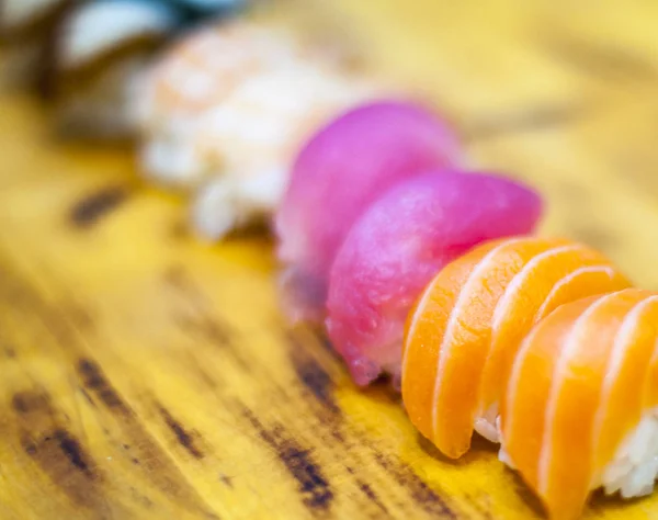 Eating Sushi with chopsticks. Sushi roll japanese food in restaurant. California Sushi roll set with salmon, vegetables, flying fish roe and caviar closeup. Japan restaurant menu