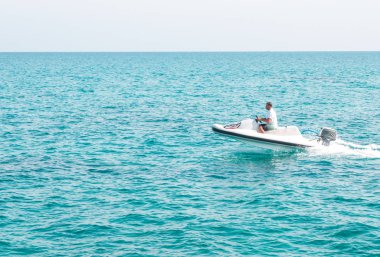 İnsanlar üzerinde deniz taşıtları sürme. Yaz eğlencesi. Deniz taşıtları üzerinde sürme için etkin olan kişileri.