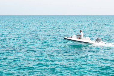 İnsanlar üzerinde deniz taşıtları sürme. Yaz eğlencesi. Deniz taşıtları üzerinde sürme için etkin olan kişileri.