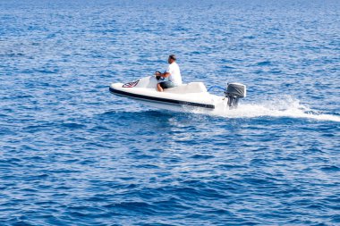 İnsanlar üzerinde deniz taşıtları sürme. Yaz eğlencesi. Deniz taşıtları üzerinde sürme için etkin olan kişileri.