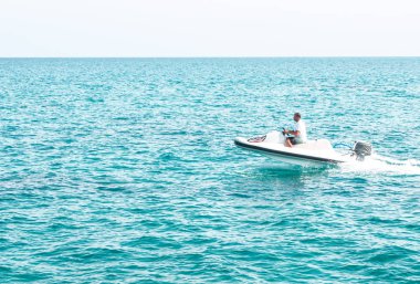 İnsanlar üzerinde deniz taşıtları sürme. Yaz eğlencesi. Deniz taşıtları üzerinde sürme için etkin olan kişileri.