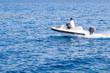 İnsanlar üzerinde deniz taşıtları sürme. Yaz eğlencesi. Deniz taşıtları üzerinde sürme için etkin olan kişileri.