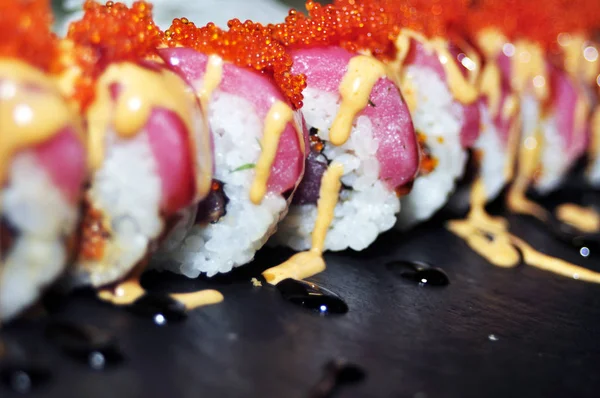 Sushis on plate at japanese restaurant banner panoramic background. Closeup of Aburi Oshi sushi, seared salmon box pressed vinegared rice, Osaka region, Japan travel. Header crop.