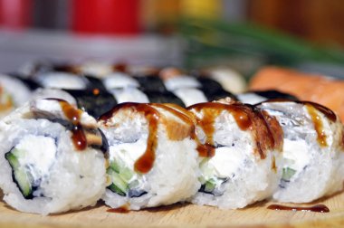 Koyu arkaplanda yemek çubukları olan suşi rulolarının yakın çekimi