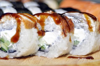 Yılan balığı suşi plastik kutu ambalaj tepsisinde siyah taş arduvaz arka plan üzerine alır.