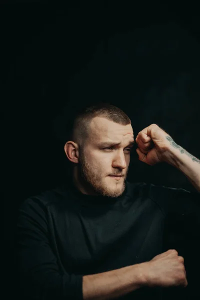 Handsome bearded guy. Dark studio photos