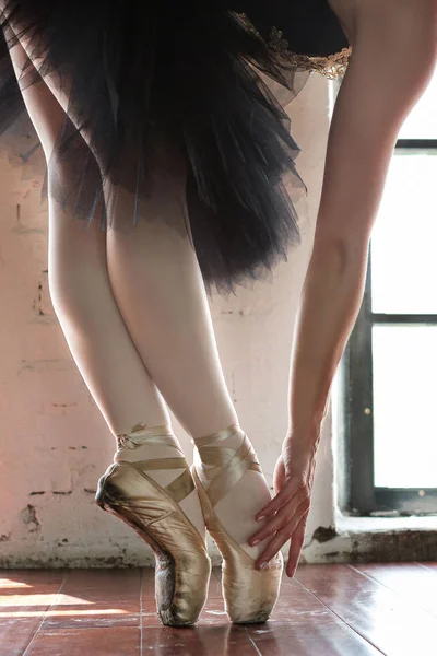 一个芭蕾舞演员的手和脚 一个芭蕾舞演员的腿特写镜头 一个芭蕾演员的腿在旧的点 在大厅里排练芭蕾舞演员 从窗户发出的等高线灯 木地板 — 图库照片