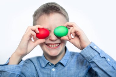 Neşeli çocuk kırmızı ve yeşil yumurta tutuyor. Paskalya yumurtaları. Tatil için hazırlık. Paskalya. Portre