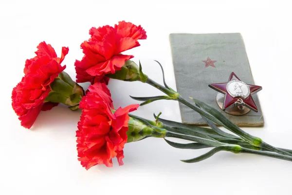 Three carnations, the Order of the Red Star, a military book on — Stock Photo, Image