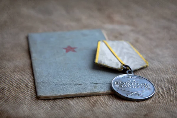 El libro del soldado y una medalla al mérito militar en una lona. Cl — Foto de Stock