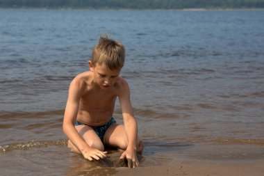 Çocuk kum plaj rakamları oluşturur.