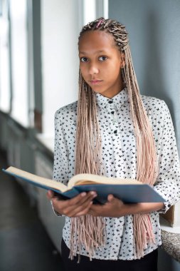 Dreadlocks ve bir kitap ile bir kız okulu corr duruyor