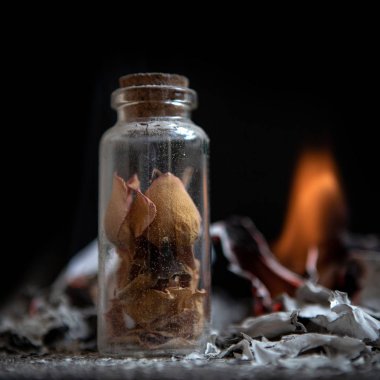 Dişi avuç içi kül. gül yaprakları ile bir şişe. Anılar ve