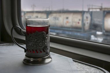 Tren bölmesindeki masada bir bardak çay,