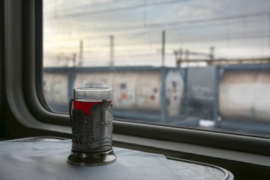 Tren bölmesindeki masada bir bardak çay. Dışında