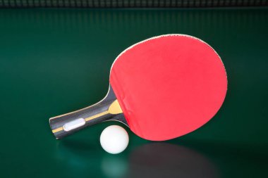 ping-pong raket ve yeşil bir masada bir top. Masa tenisi net.