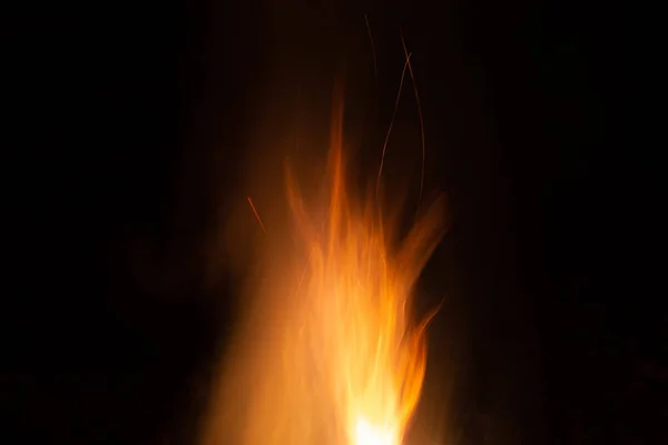 V noci Bonfire. Nádherné oranžové jiskřky na černém pozadí — Stock fotografie