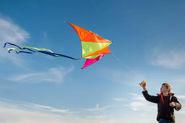 Um rapaz de 10 anos com um papagaio contra o céu. Brilhante ensolarado — Fotografia de Stock