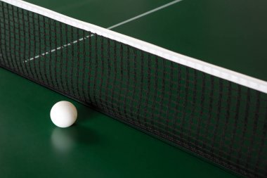 NET yanında yeşil bir masada bir ping-pong topu. 