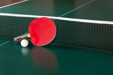 ping-pong raket ve yeşil bir masada bir top. Masa tenisi net.
