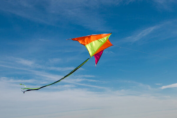 Flying a kite. Bright kite against the blue sky. Sunny day. 