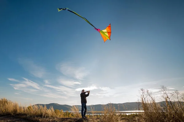 Un ragazzo con un aquilone contro il cielo blu. Giornata di sole brillante. Volo — Foto Stock